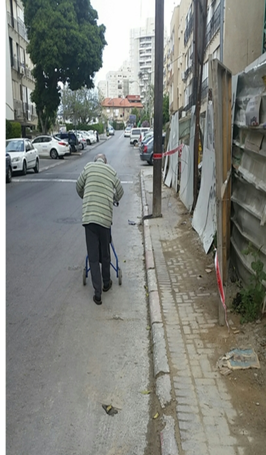 קשיש הולך בכביש בצורה מסוכנת בגלל חוסר במדרכה