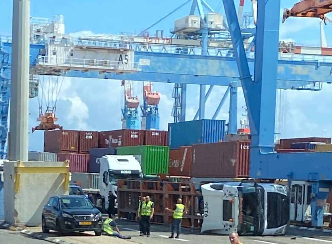 תאונת עבודה בנמל חיפה: משאית התהפכה בעת פריקת מכולה על ידי מנוף | צפו בתיעוד