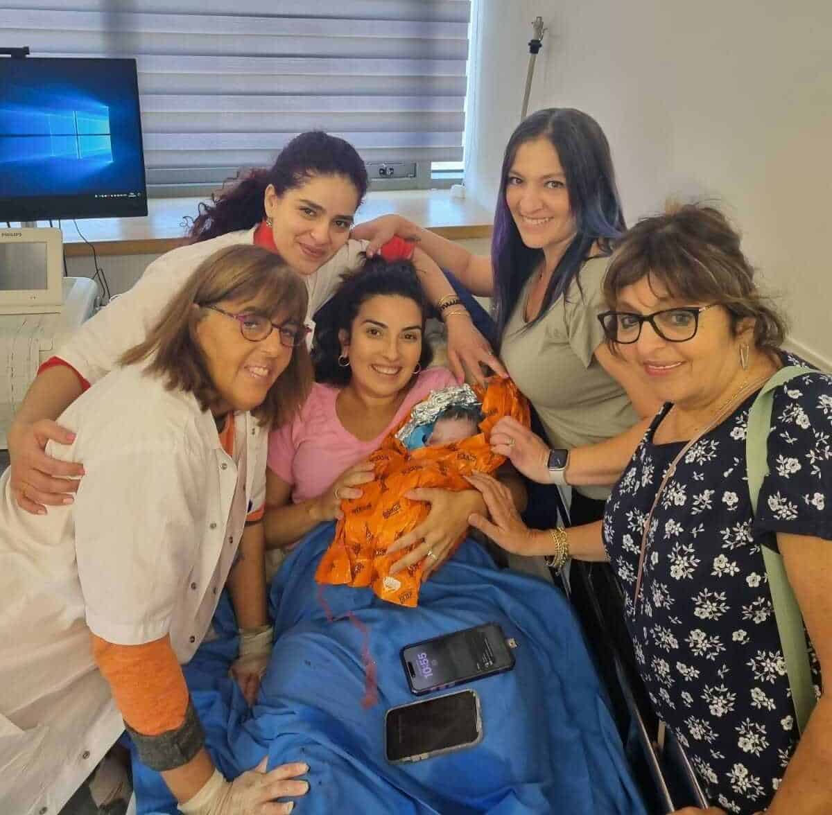 תמונת הניצחון צוות מכבי מקיף את המטופלת ביחד עם התינוקת החדשה e1713743591378